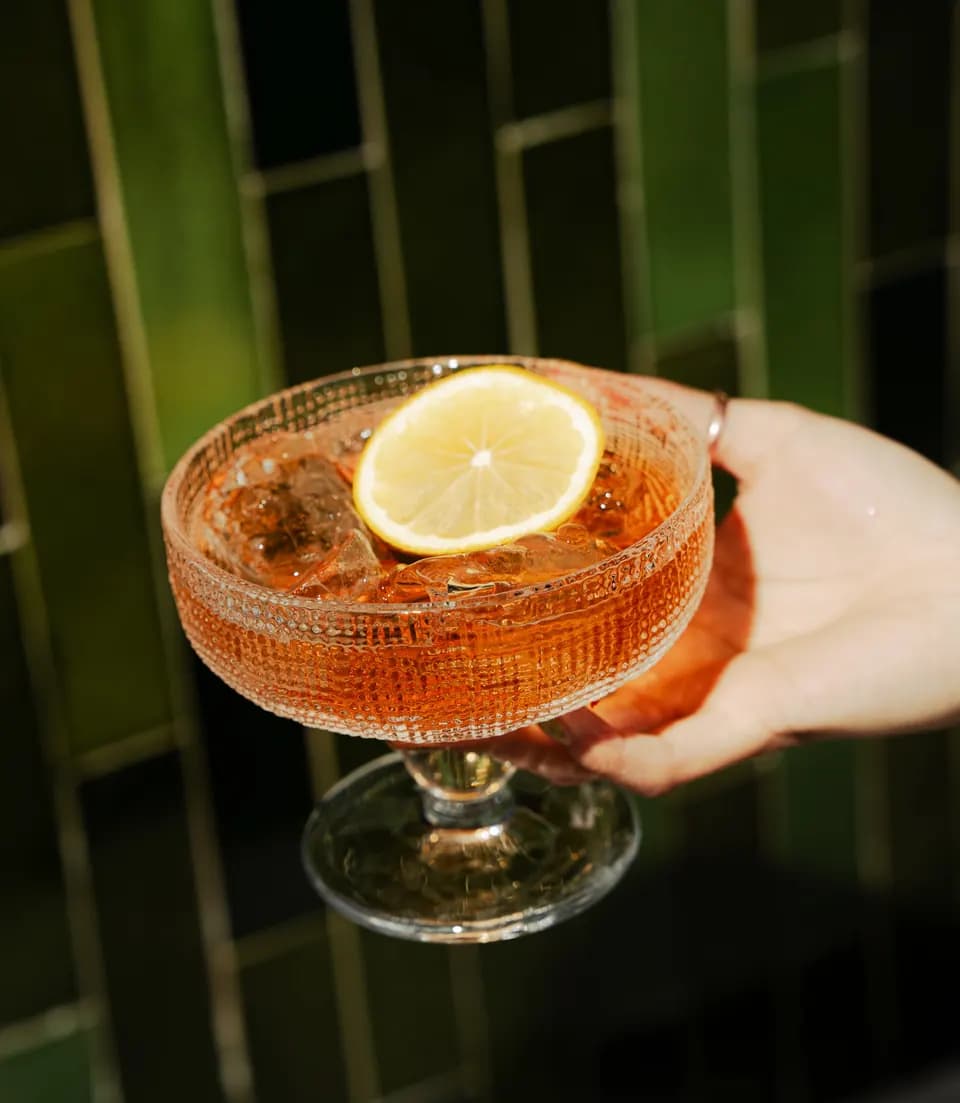 Coctel ámbar con rodaja de limón en Barra Simona